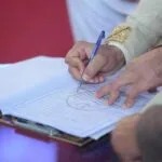 Pan młody podpisuje kontrakt małżeński podczas tradycyjnego ślubu