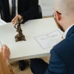 Podpisywanie dokumentów rozwodowych w biurze przez kobietę i prawnika
