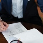 Prawnik przy biurku podpisuje dokumenty pełnomocnictwa