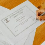 Dłoń podpisująca oficjalny dokument notarialny dla dziecka