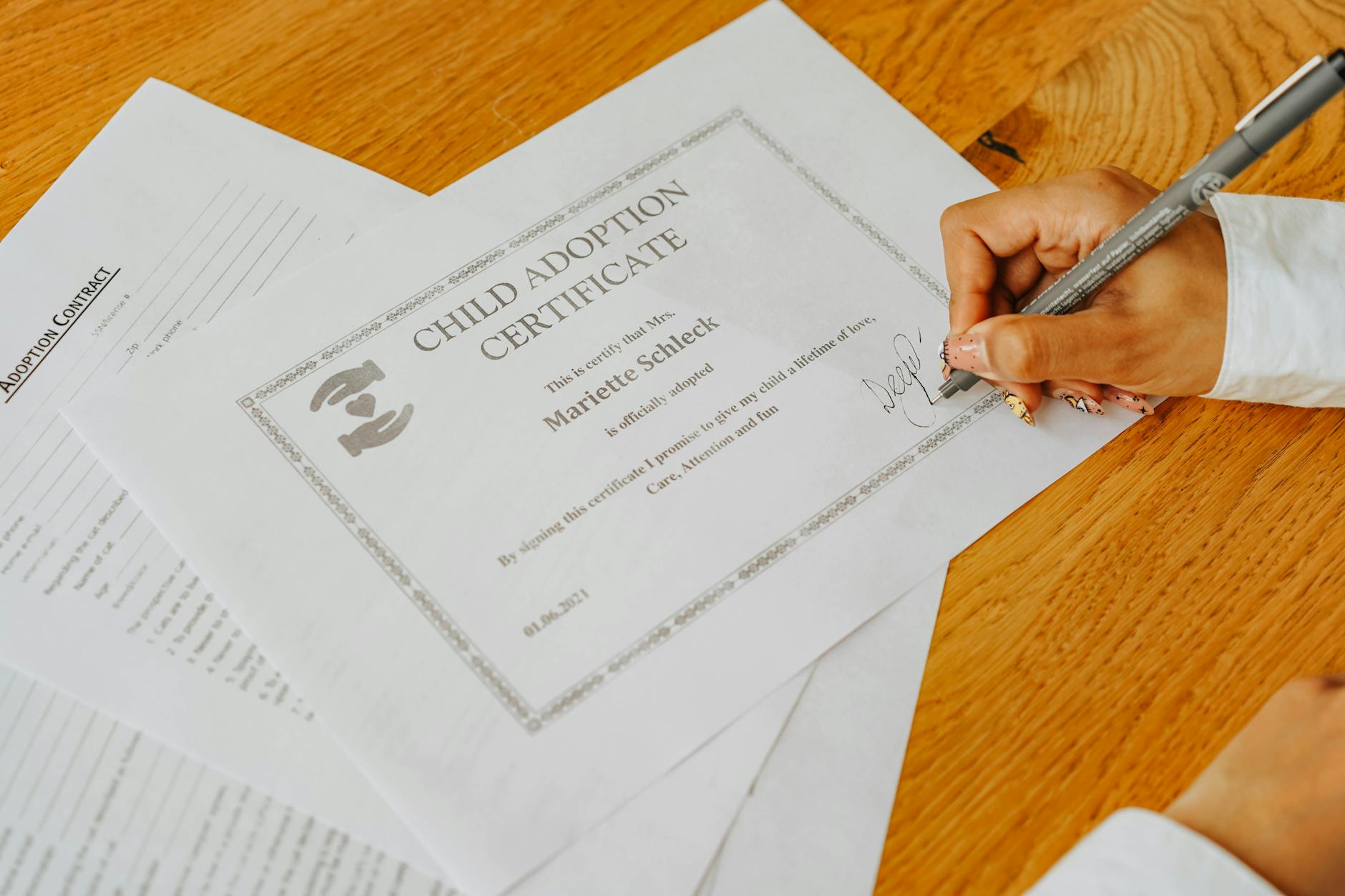 Dłoń podpisująca oficjalny dokument notarialny dla dziecka