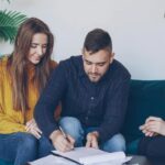 Małżeństwo podpisuje dokumenty majątkowe przy doradcy finansowym