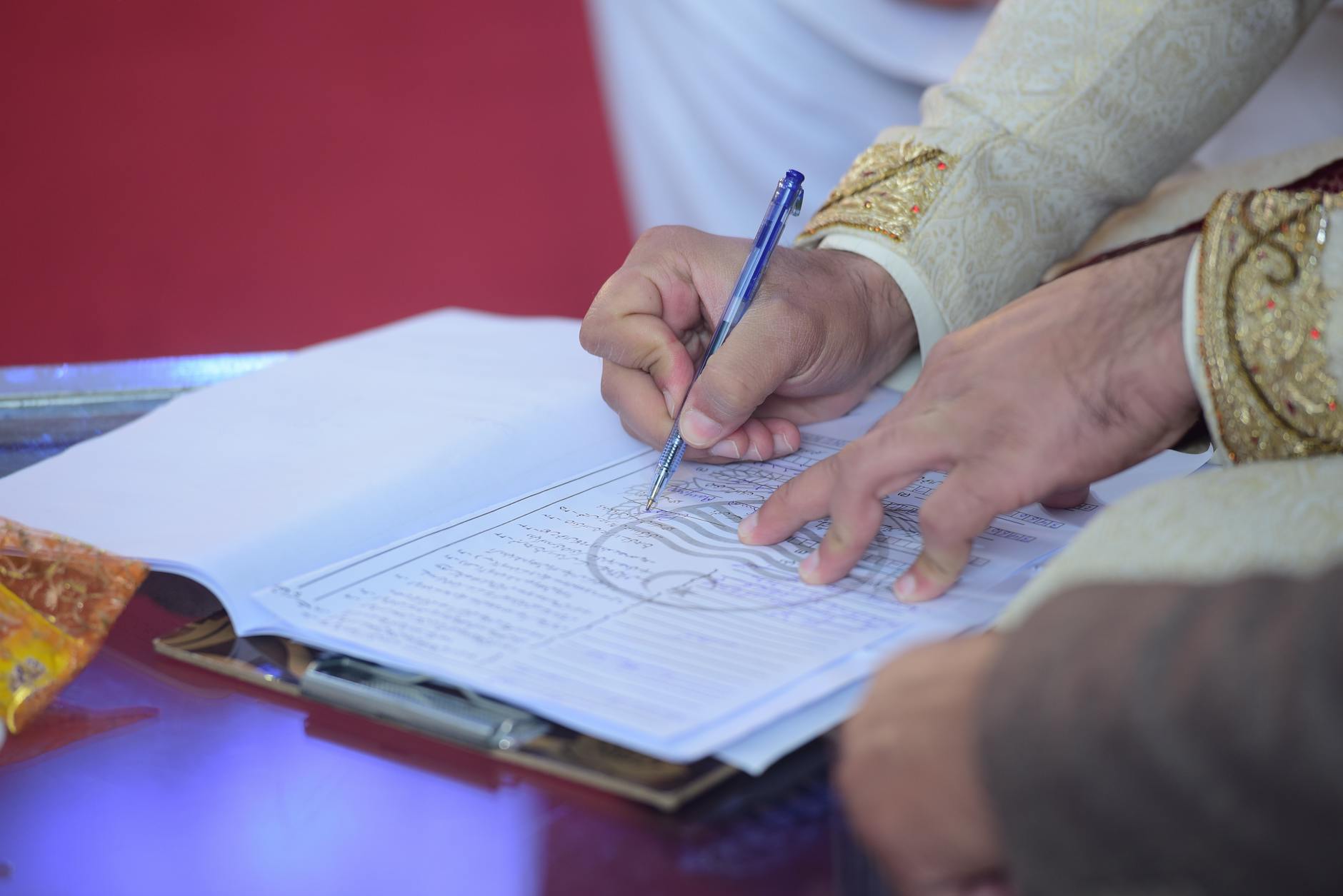 Pan młody podpisuje kontrakt małżeński podczas pakistańskiej ceremonii