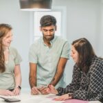 Trzech specjalistów rozmawia przy stole o zakupie nieruchomości