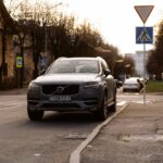 Volvo XC90 zaparkowane przy ulicy w mieście, otoczone znakami drogowymi
