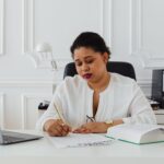 Prawniczka podpisuje dokumenty przy biurku, przygotowanie testamentu